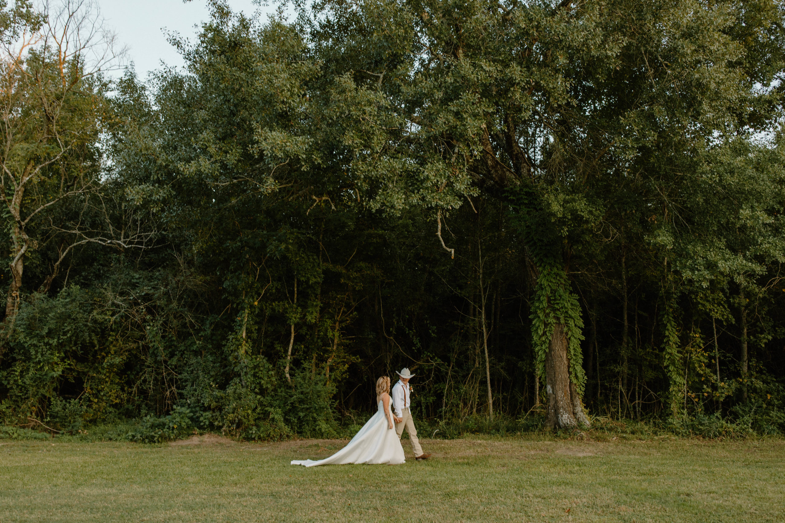 Couple walking through a field - Intimate backyard wedding